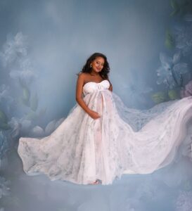 Calgary maternity photoshoot, pregnant woman wearing blue gown in front of blue floral backdrop