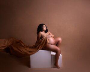 maternity photography by Tiara Tran, pregnant naked woman with flowing fabric in a photography studio