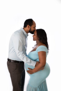 Husband and wife kissing in a maternity photoshoot in Calgary