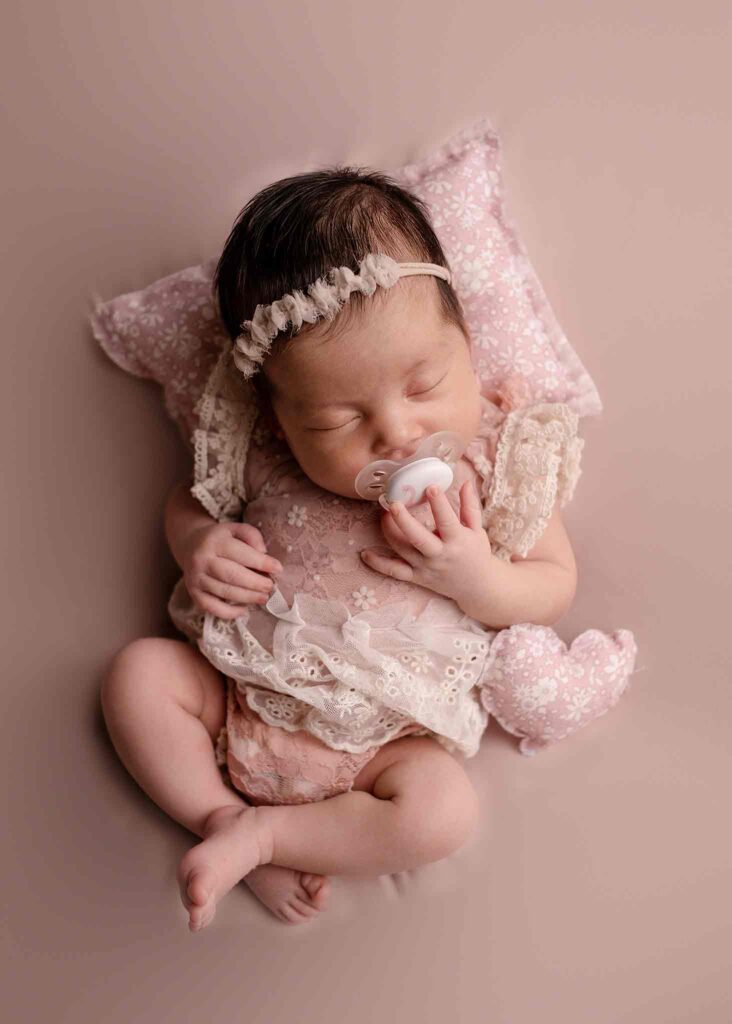 newborn baby girl sleeping for a studio photography in Calgary, pink set ups, cute outfit