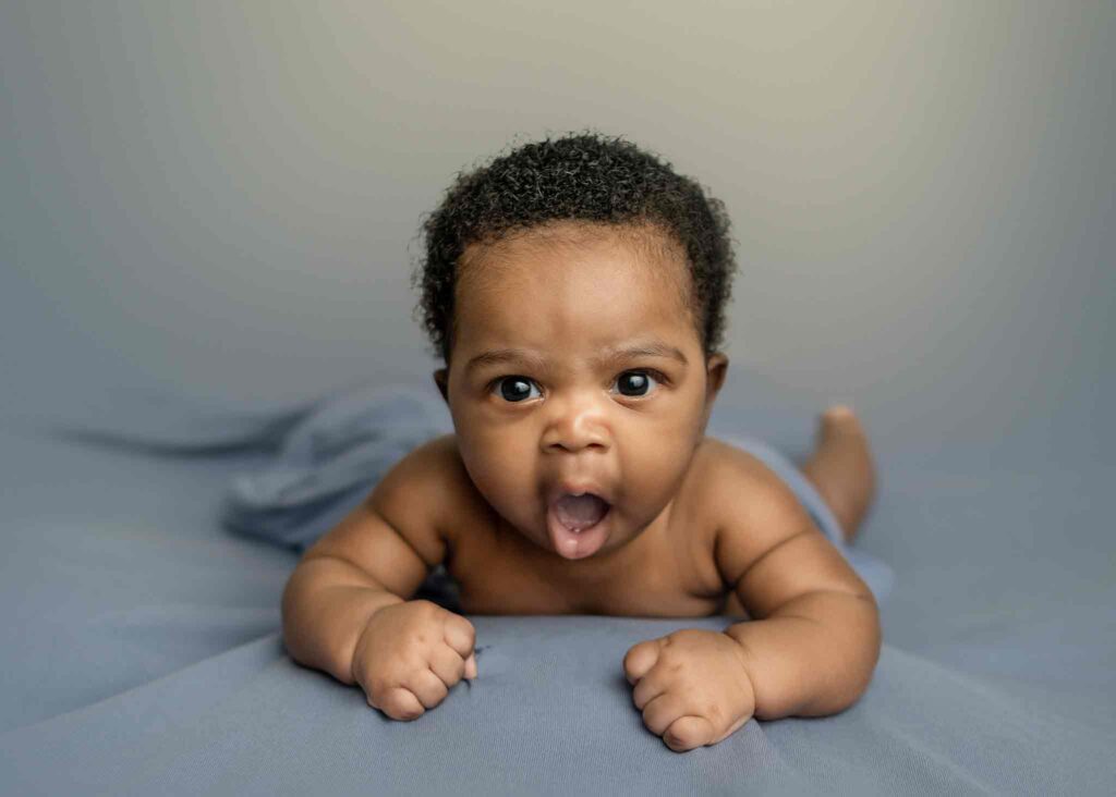 One month old baby posing in a blue backdrop - Tiara Tran Photography Calgary newborn photoshoot