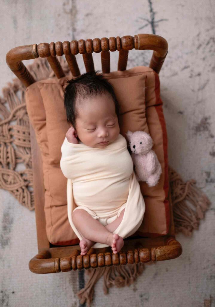 Calgary newborn baby photography - baby sleeping in a tiny bed