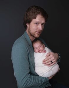 New dad holding his baby in a newborn photography studio in Calgary