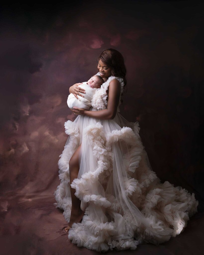 Mom wearing a luxury gown holding her baby for photography session in Calgary