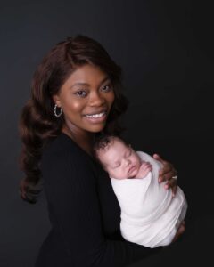 New mom holding her baby in a newborn photography studio in Calgary