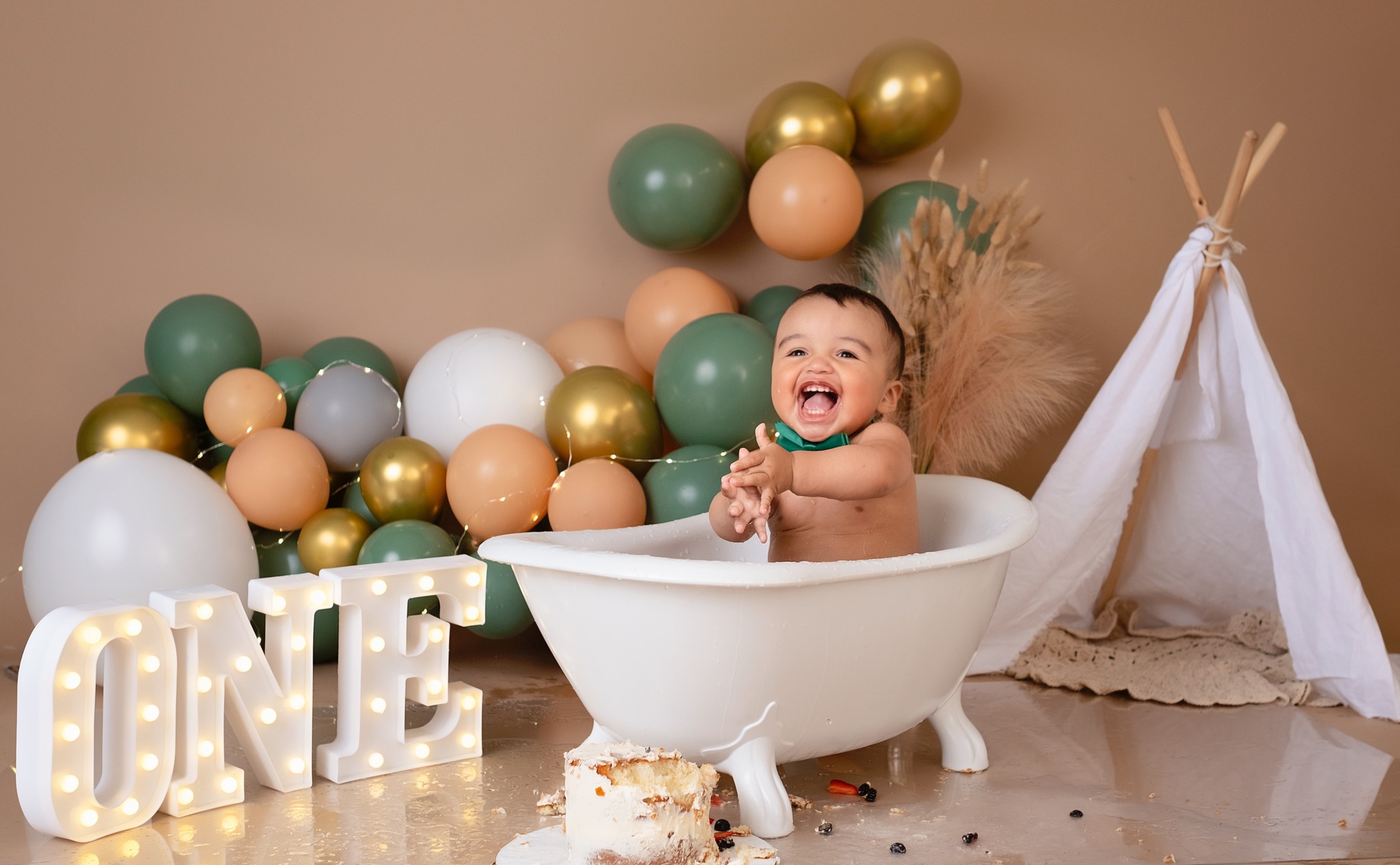 Baby boy doing a splash after a cake smash photoshoot in Calgary