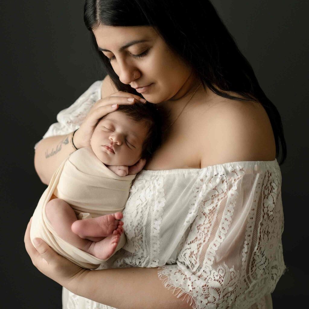 New mom holding baby for a photography studio photoshoot - newborn photography in Calgary